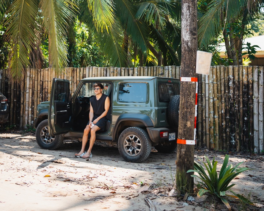 a man sitting in a green 4x4 car in Puerto Viejo