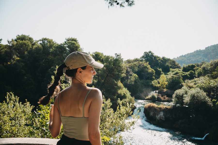 Young woman looking at a waterfall in Krka National Park