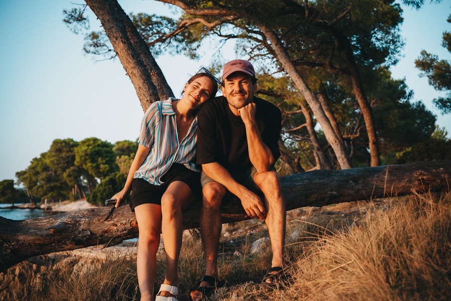 Couple on a log by the sea in Šibenik, Croatia