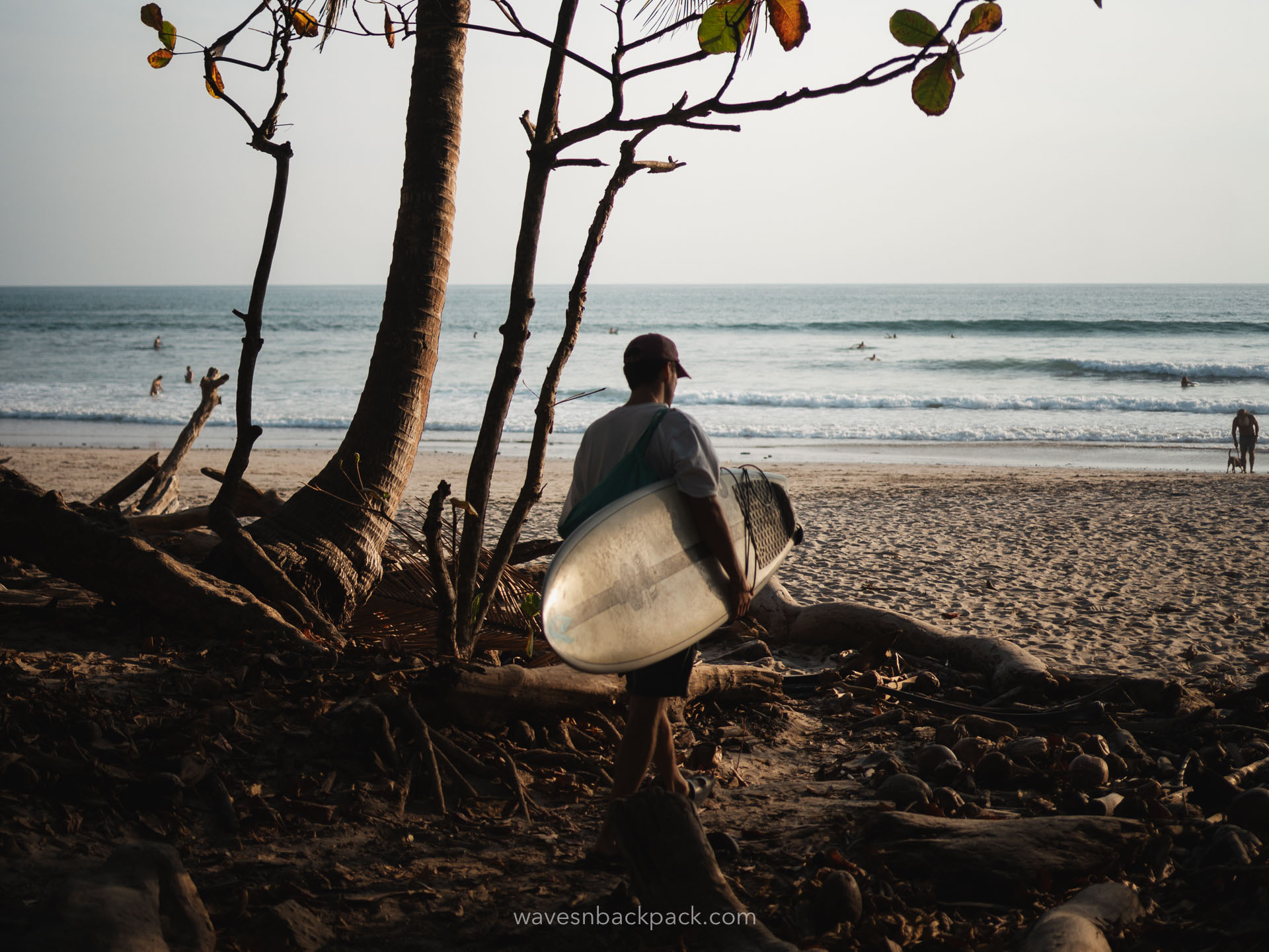 young man with a surfboard in front of the beach in Santa Teresa